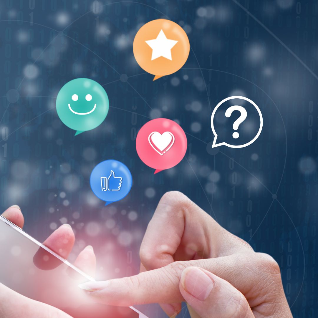 Woman's hands holding a mobile phone with feedback images -- thumbs up, smile, heart and star